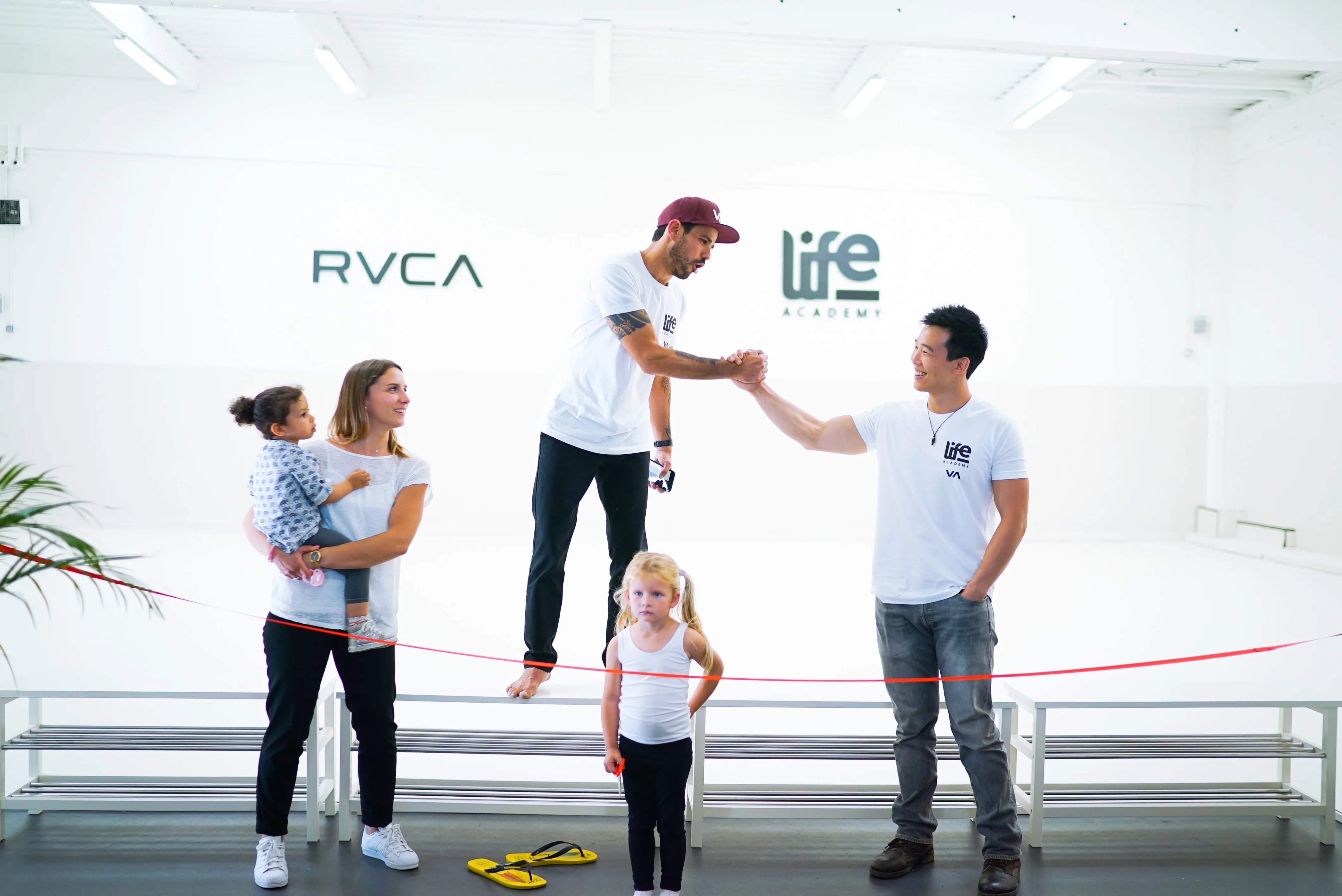 Inauguration de Life Academy : coupe du ruban devant le mur aux logos RVCA et life