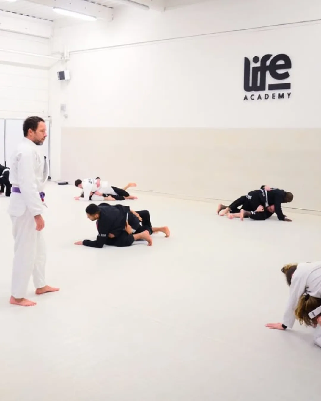 Cours adultes en binômes dans la grande salle blanche