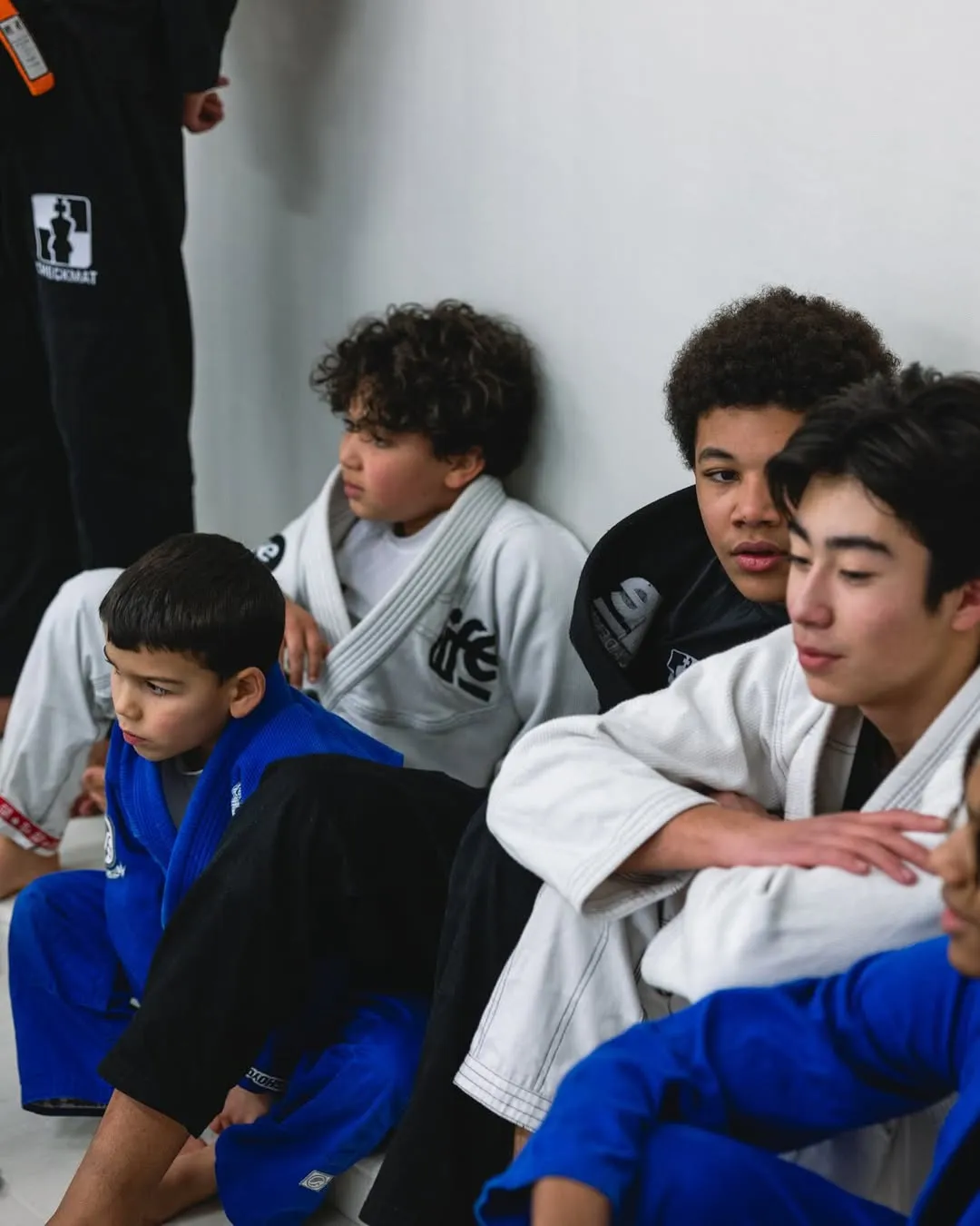 Des enfants en kimono assis au bord du tatami, attentifs