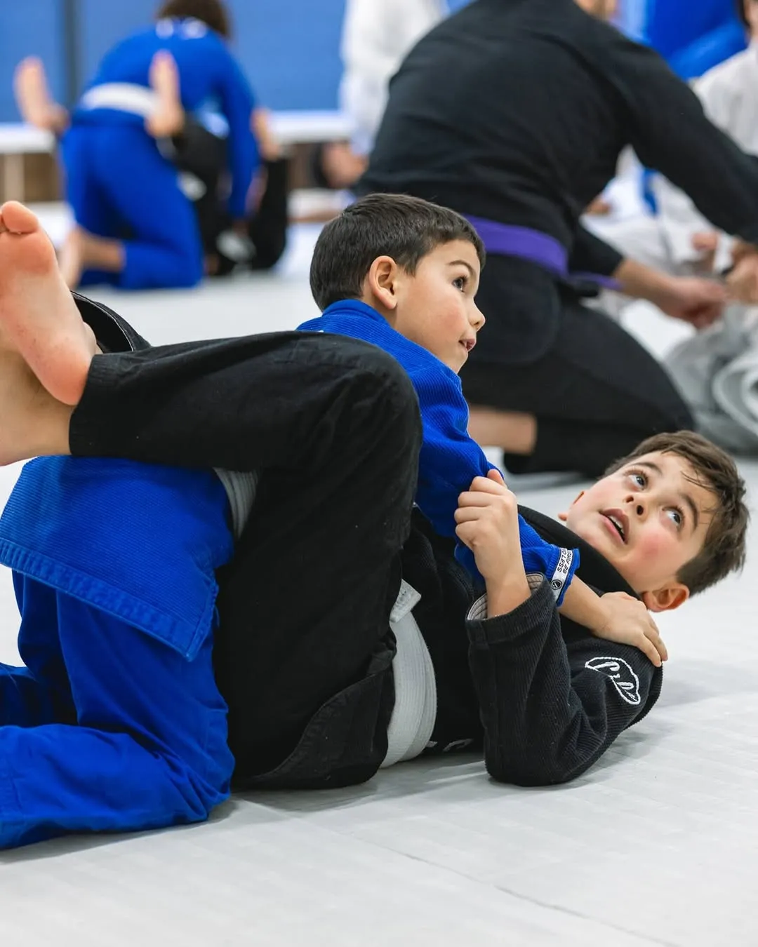 Un enfant sourit au sol pendant un exercice